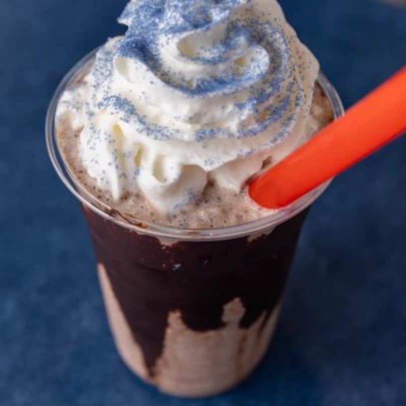 La Bella Bean's chocolate coffee drink with whipped cream, blue sprinkles, and an orange straw.